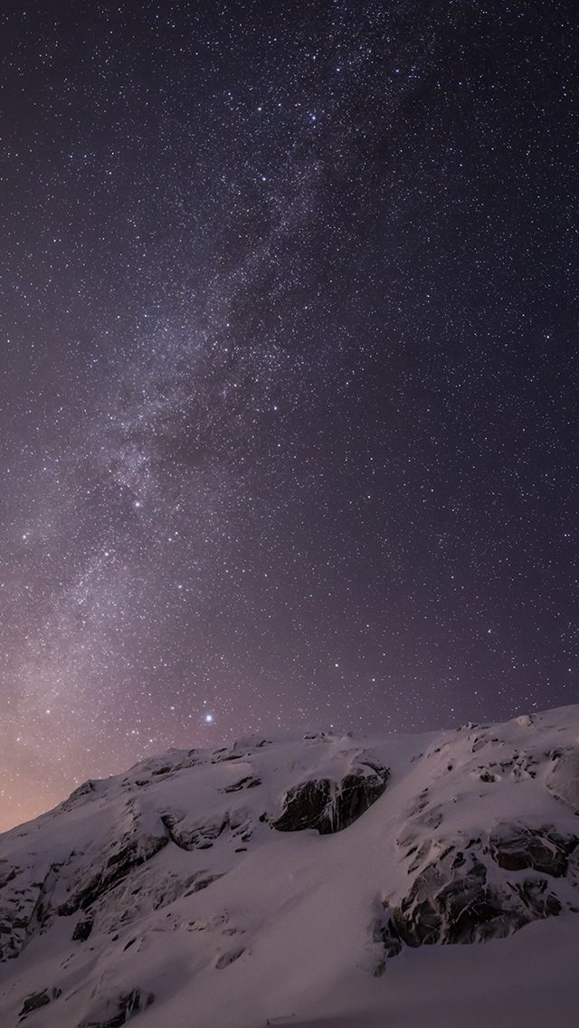 an iphone with the clock displayed on it's screen and mountains in the background