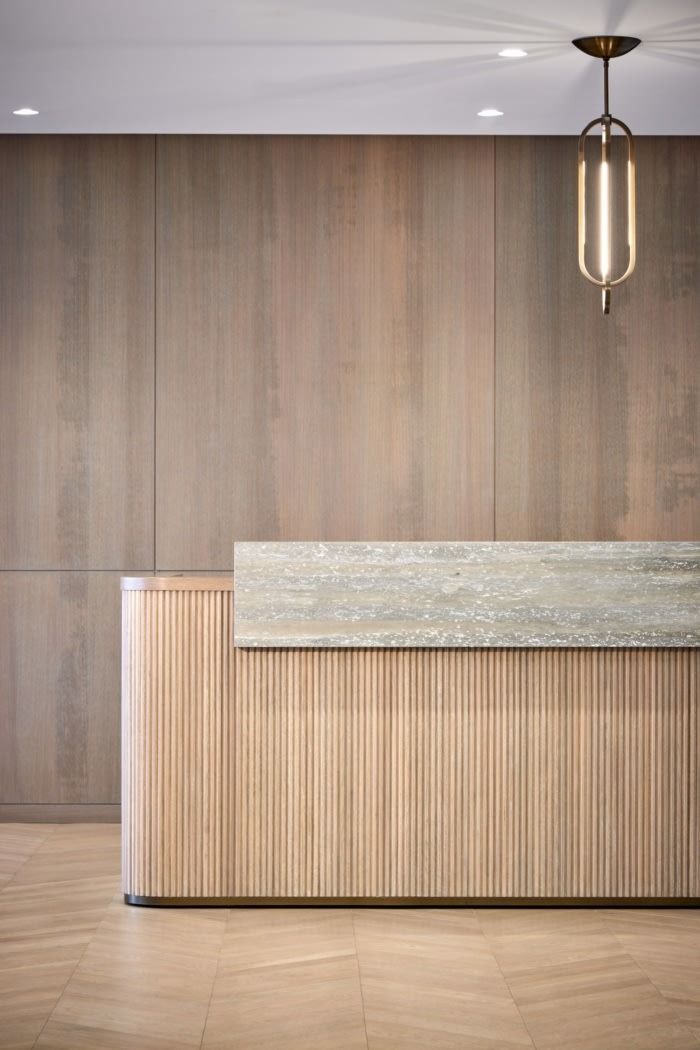 an empty reception area with wood paneling and a light fixture hanging from the ceiling