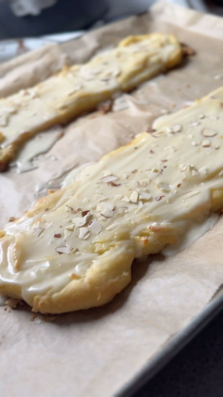 some kind of food that is sitting on a tray with wax paper and baking utensils in the background