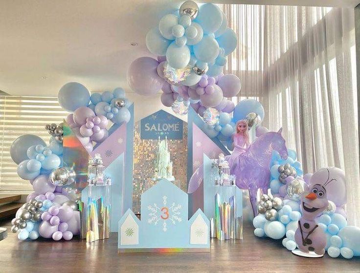 a table with balloons and decorations for a frozen princess birthday party on it's centerpieces