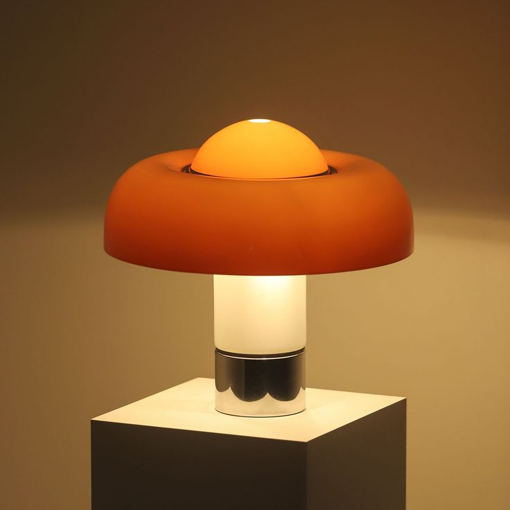 The Brumbry Table Lamp by Dekorfine is a perfect blend of modern design and vibrant color. Featuring a striking orange glass shade and a sleek metal base, this lamp adds a pop of color and contemporary style to any space. The smooth, rounded lines of the glass shade diffuse light beautifully, creating a warm and inviting atmosphere. Ideal for desks, bedside tables, or living room accents, the Brumbry Table Lamp enhances your decor with its unique aesthetic and high-quality craftsmanship. If you Guzzini Lamp, Harvey Guzzini, Luigi Massoni, Orange Table Lamps, Desktop Lamp, Ingo Maurer, Orange Table, Luxury Lamps, Floor Lamps Living Room