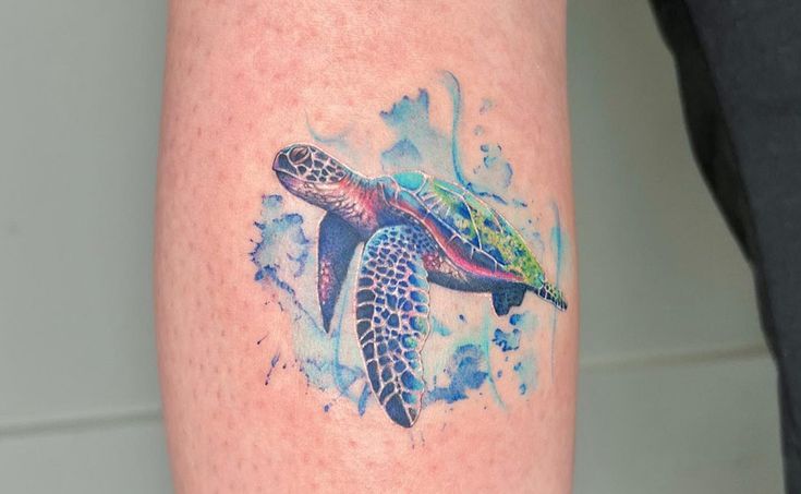 a watercolor tattoo of a sea turtle on the leg