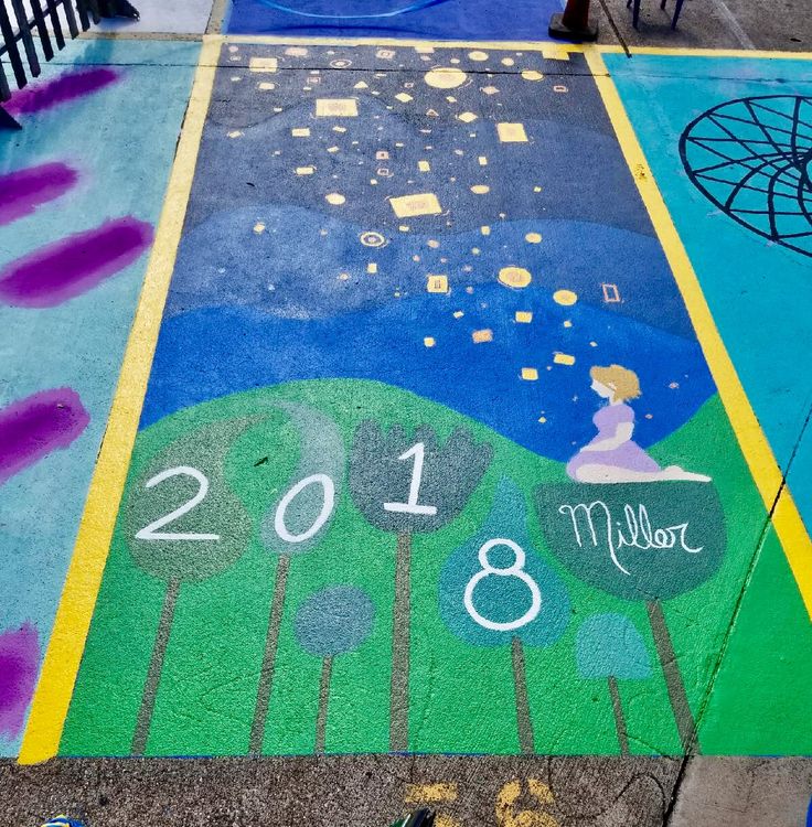 a sidewalk painted with the year 2018 and an image of a woman sitting on a bench