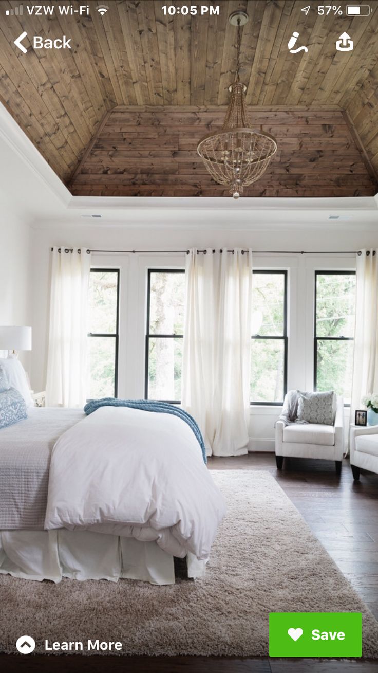 a bedroom with white furniture and wood ceiling