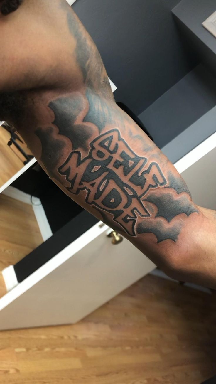 a man with a tattoo on his arm that reads, army maddra in black ink