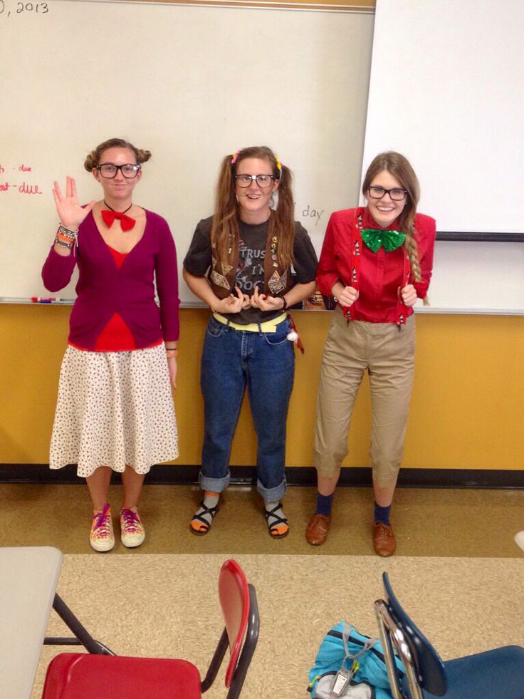 three girls standing in front of a whiteboard with their hands up to the camera