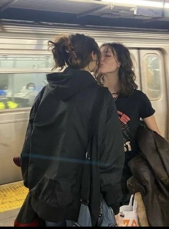 two people are kissing on the subway platform