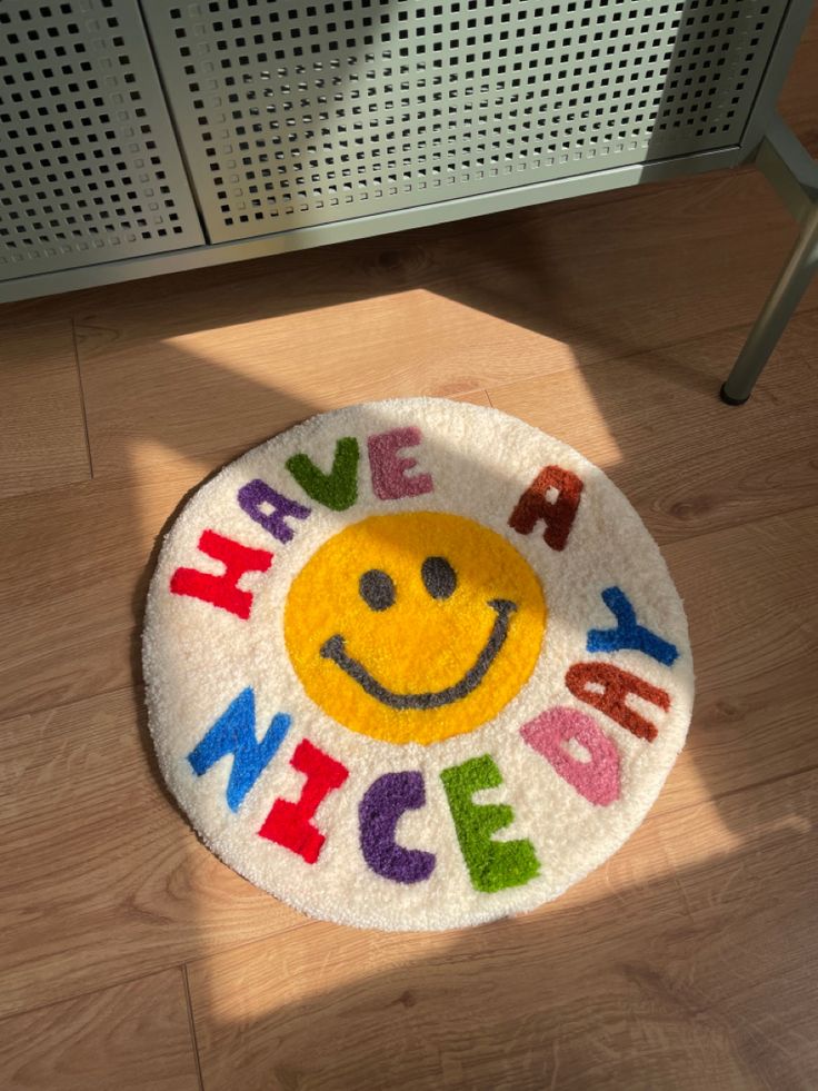 a smiley face rug with the words have a nice day written in multicolored letters