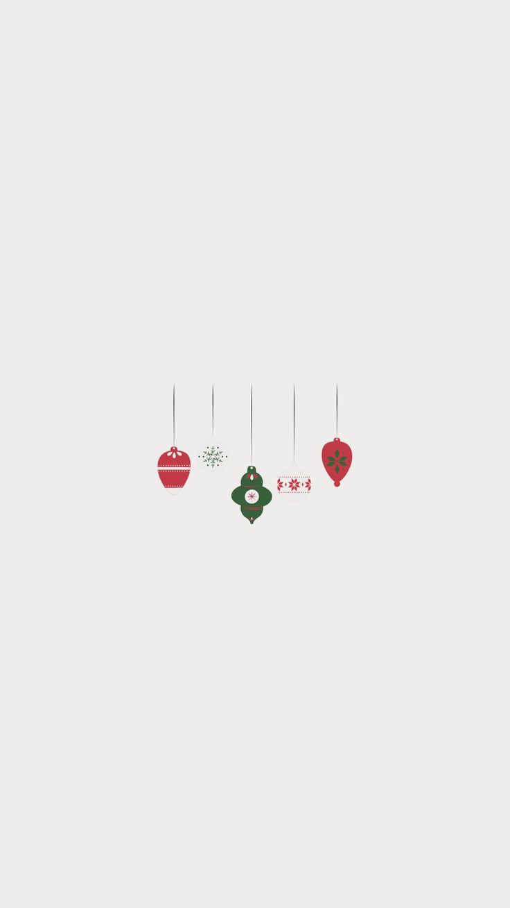 three ornaments hanging from strings on a white wall with red, green and blue decorations