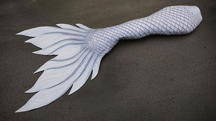 a white mermaid tail laying on the ground