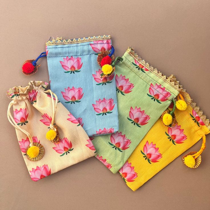 four bags with flowers and tassels on them