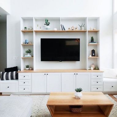 a living room filled with furniture and a flat screen tv mounted on a wall above a wooden coffee table