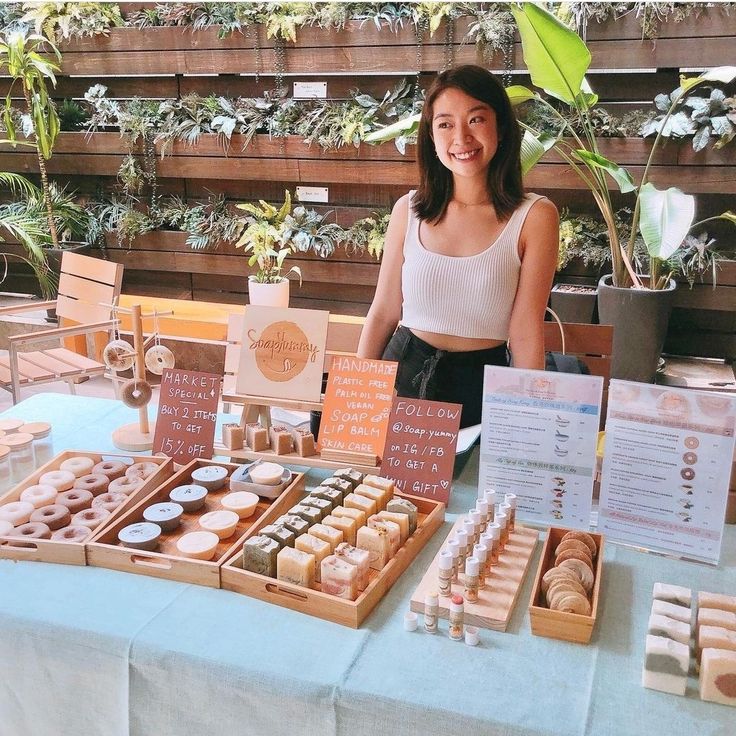 a woman standing in front of a table filled with different types of doughnuts