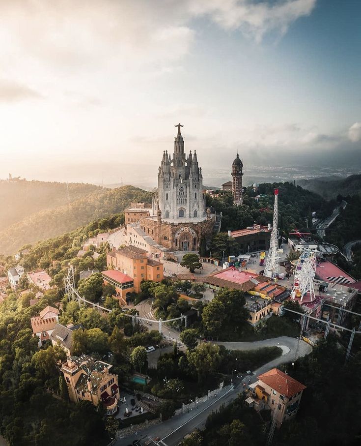 an aerial view of a castle in the middle of trees and buildings on top of a hill