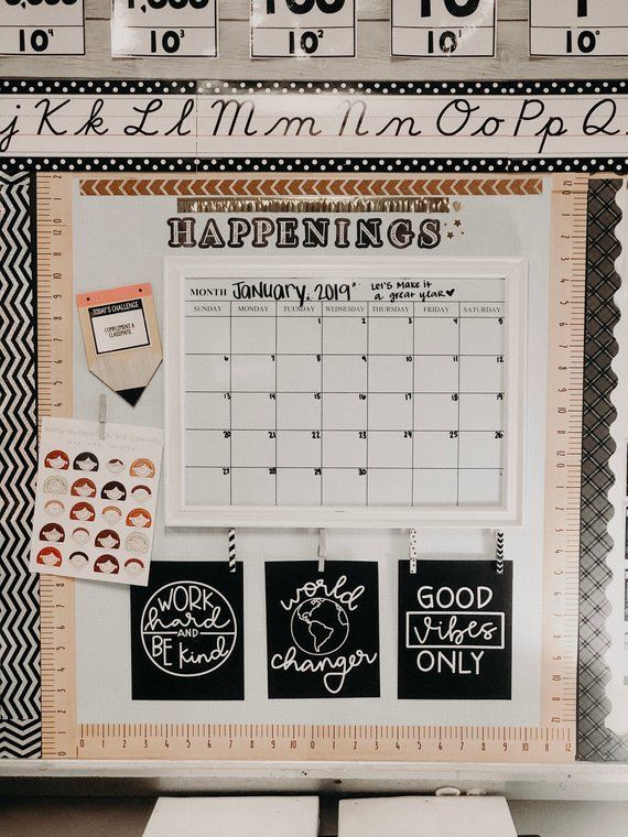 a desk with calendars and magnets on it in front of a whiteboard