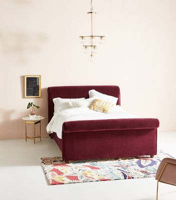 a bedroom with a bed, chair and rugs in it's center area