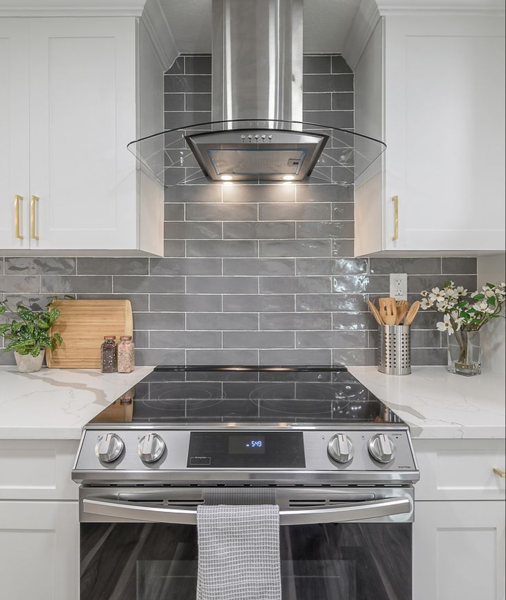 a stove top oven sitting inside of a kitchen next to white cabinets and counter tops