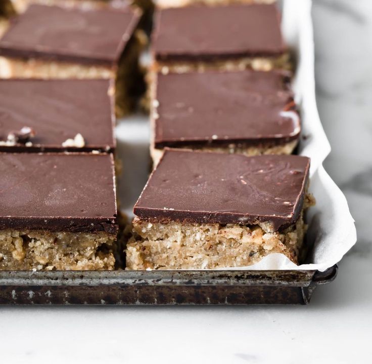 there are many pieces of chocolate and nuts on the trays that is ready to be eaten