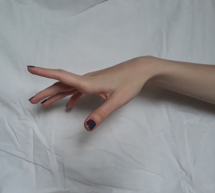 a woman's hand on top of a white sheet