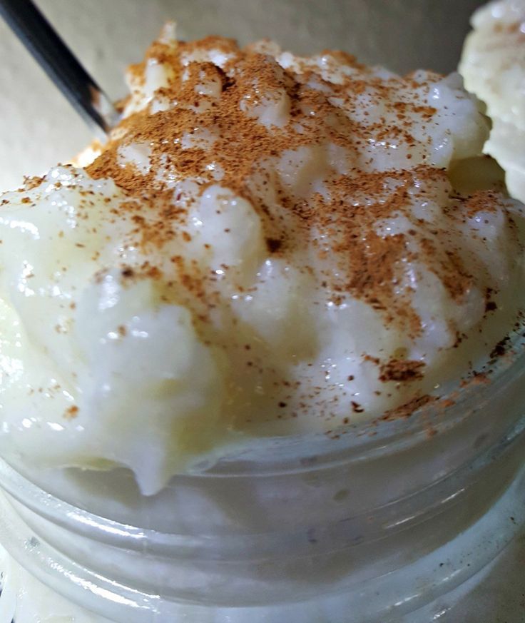 a dessert in a jar with cinnamon sprinkles and whipped cream on top