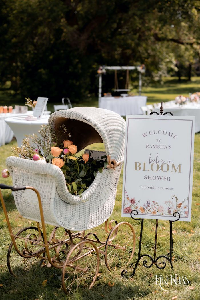 an old fashioned baby carriage with flowers in it and a welcome sign on the back