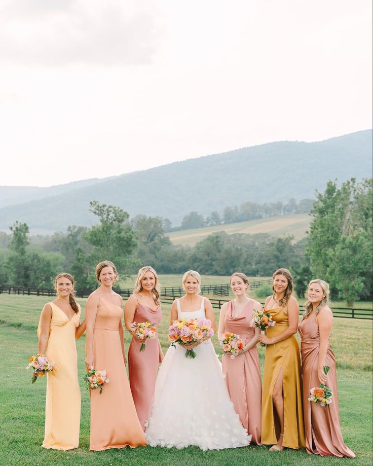 a group of women standing next to each other on top of a lush green field