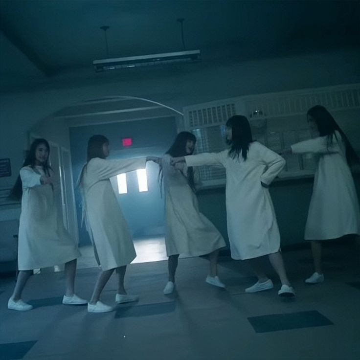 four women in white dresses are dancing together