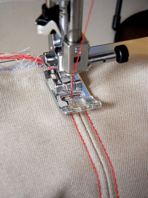 a sewing machine with red thread on it's side and the needle hooked up