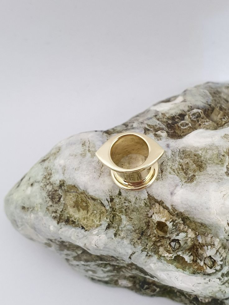 a gold ring sitting on top of a rock