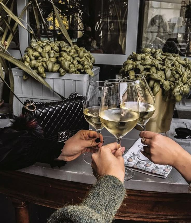 two people toasting with wine glasses on a table