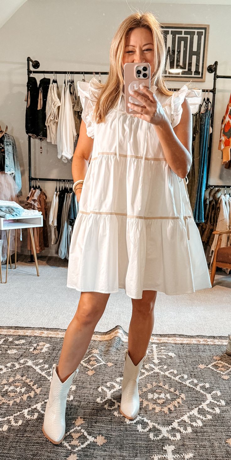 Indulge in a taste of luxury with our Poplin Tiered Dress. Crafted from 100% cotton, this structured dress exudes a rich and sophisticated look, while remaining playful with its ruffles and bows. Plus, it has pockets! This white dress boasts contrasting taupe trim and side ties for an exclusive touch. Complete your wardrobe with this ultimate girly dress. True to size. I’m shown wearing a small. Taupe Trim, Nashville Outfit, Structured Dress, Nashville Outfits, Girly Dresses, Grad Dresses, Tiered Dress, Sophisticated Look, Just A Girl