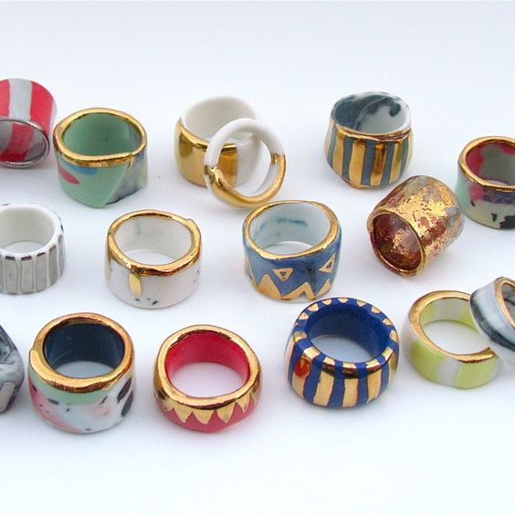 many different colored rings sitting on top of each other in front of a white background