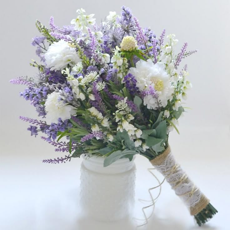 a bouquet of white and purple flowers in a vase with the words madda bell above it