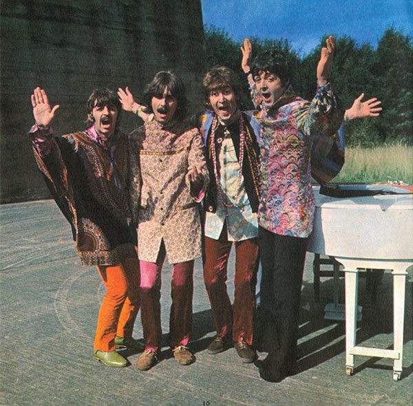 the rolling stones posing for a photo in front of a piano with their hands up