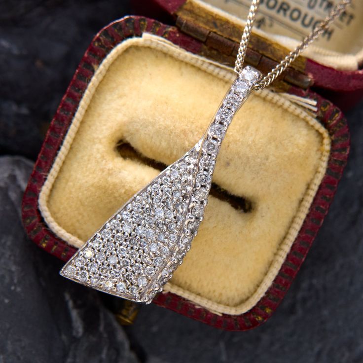 This graceful diamond ribbon pendant features seventy-seven (77) round brilliant cut diamonds that are pavé set. The pendant measures 34.5mm long, by 12.0mm wide and 5.5mm thick. It hangs on an 18 inch long, 1.0mm wide wheat chain that is finished with a lobster claw clasp. Brilliant Cut Diamond Pendant Necklace For Evening, Diamond White Necklace With Diamond Accents For Evening, Evening Brilliant Cut Diamond Pendant Necklace, Evening Diamond Cut Pendant Necklace, Art Deco Diamond Jewelry With Pave Setting, Evening Brilliant Cut Diamond White Diamond Necklace, Art Deco Diamond Pendant Necklace With Accents, Platinum Diamond Necklace With Pave Setting As Gift, Dazzling Diamond Necklace For Evening