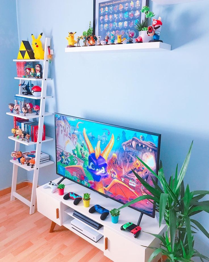 a flat screen tv sitting on top of a white shelf next to a green plant