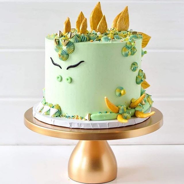 a green cake with yellow leaves on top