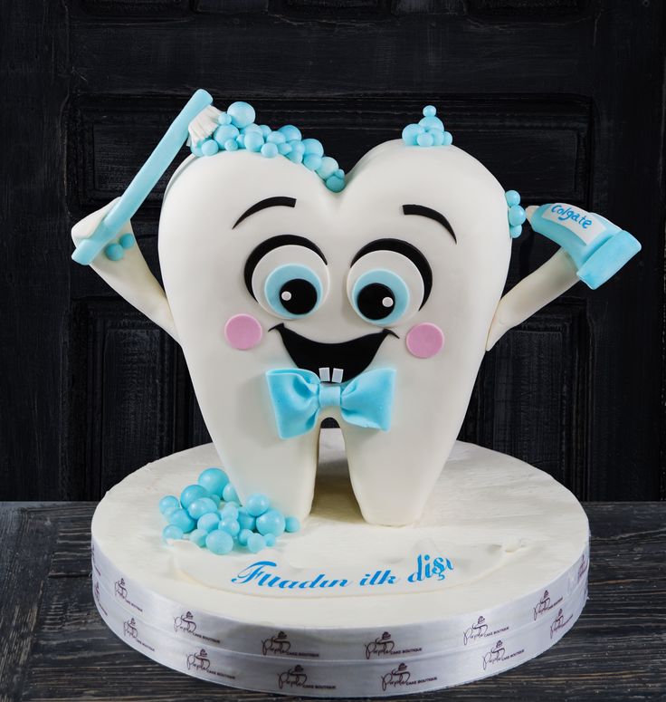 a tooth shaped cake with a bow tie on it's head and hands in the shape of a heart