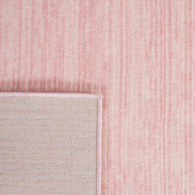 a pink and white striped wallpaper with an area rug