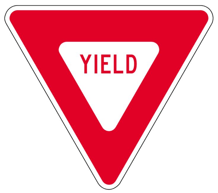 a red yield sign sitting on top of a wooden pole