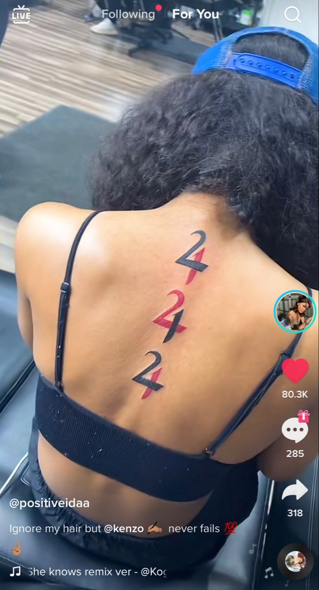 the back of a woman's head with numbers on her upper and lower back