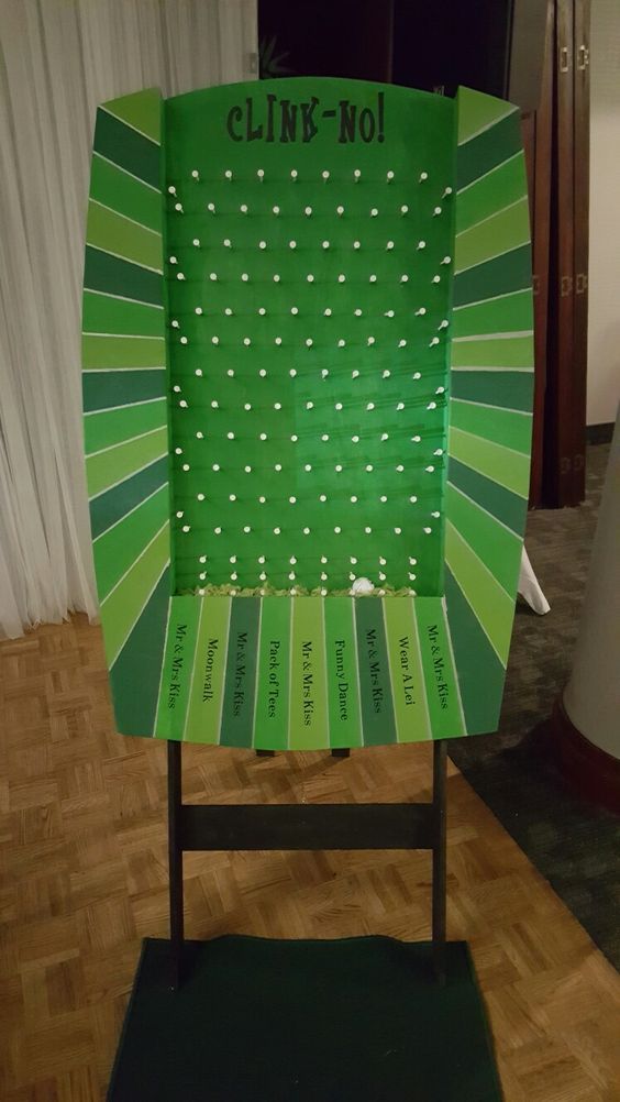 a green chair sitting on top of a hard wood floor next to a white curtain