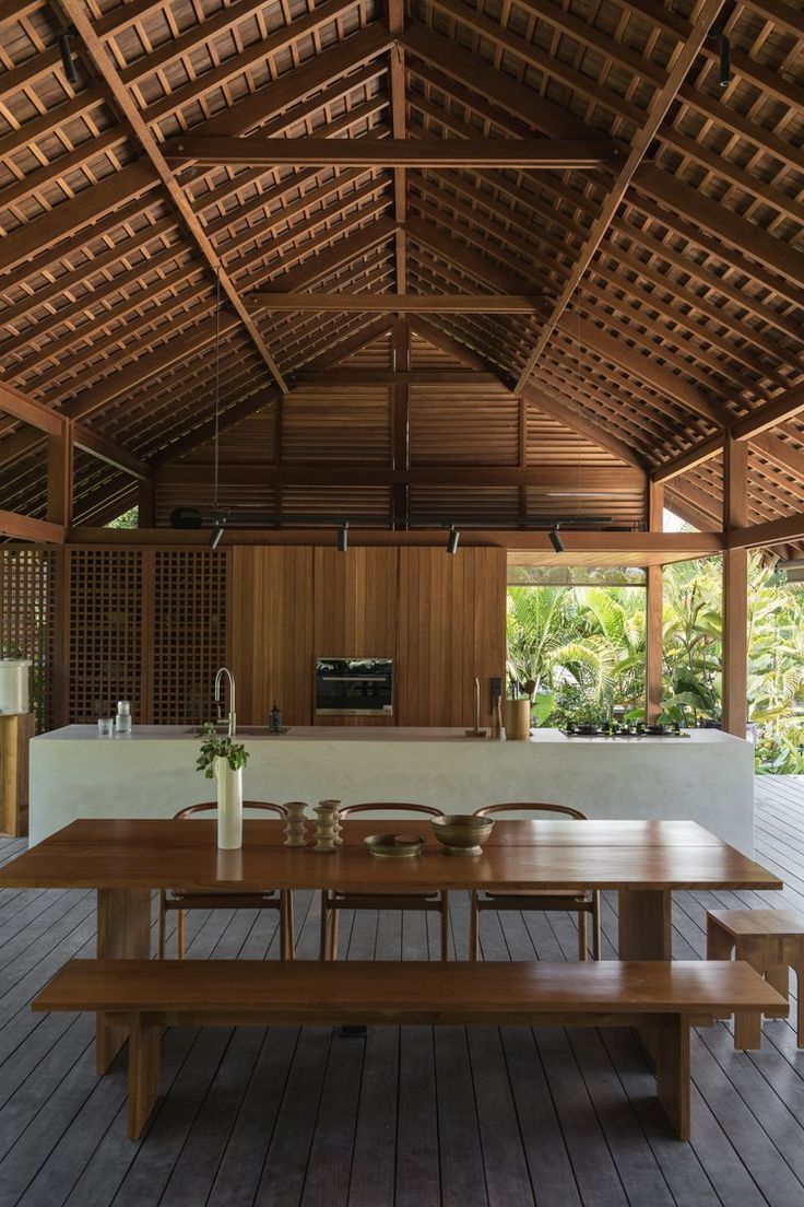 a large wooden table sitting under a roof