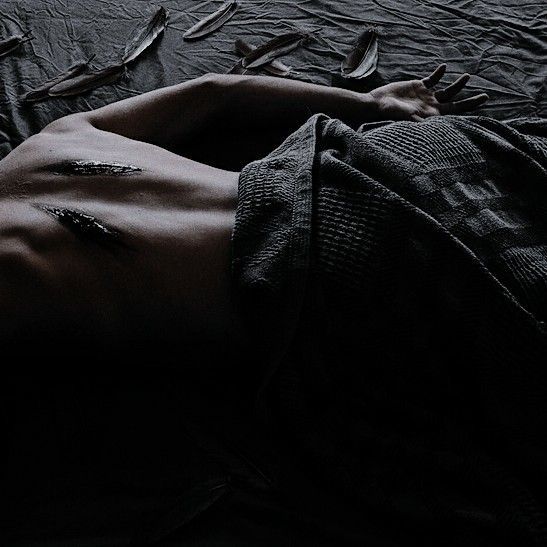 a shirtless man laying on top of a bed