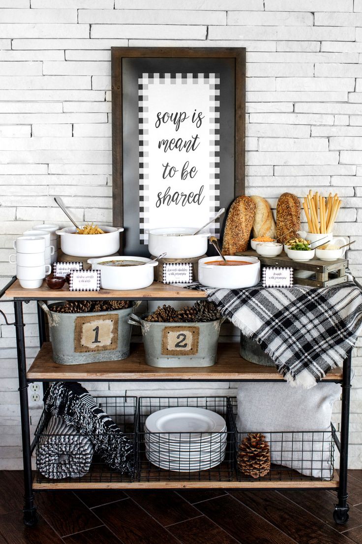 a table topped with lots of food on top of a wooden shelf next to a white brick wall