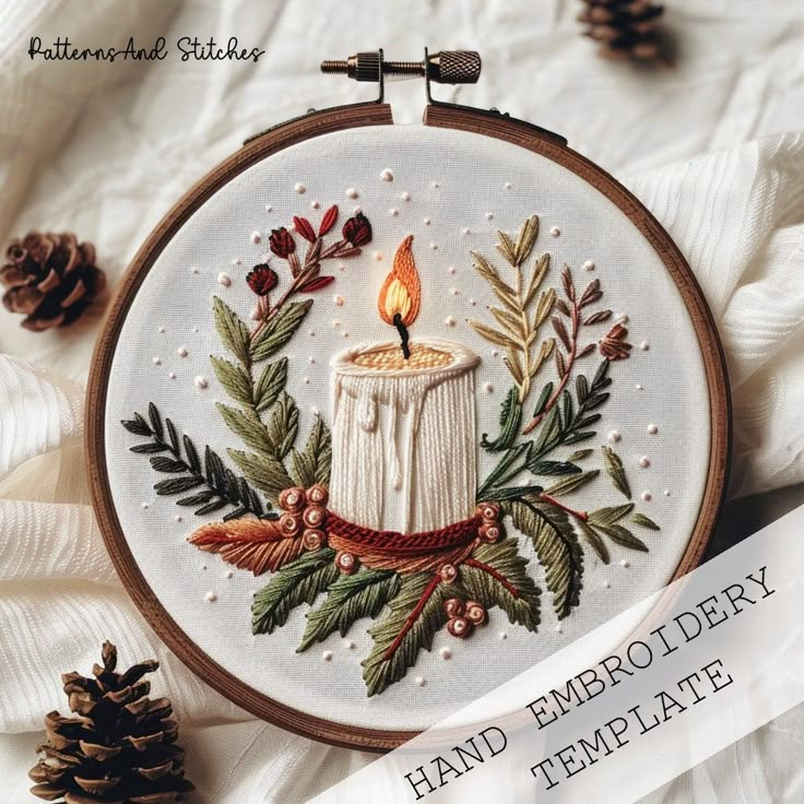 a hand embroidered candle surrounded by leaves and pine cones on a white background with the words, hand embroidery template