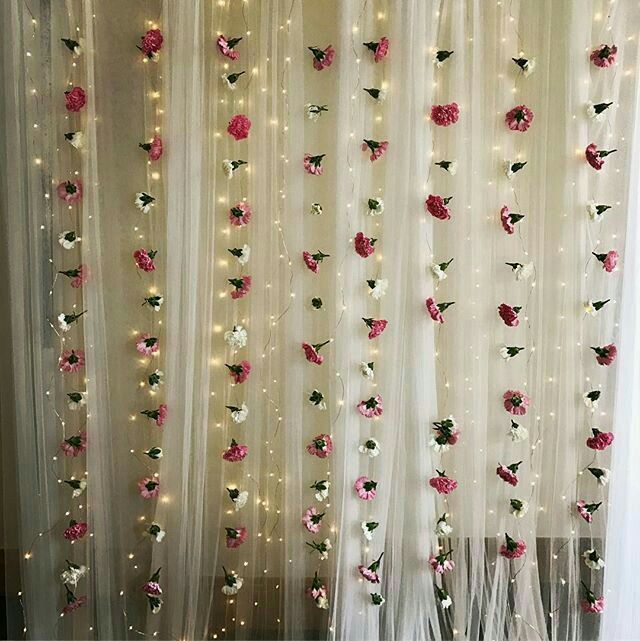 the curtains are decorated with flowers and fairy lights