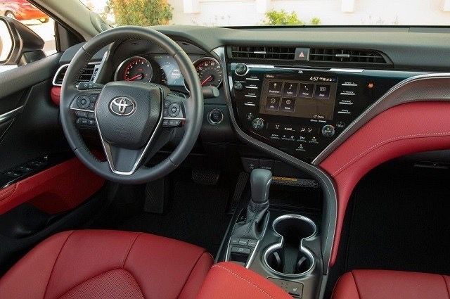 the interior of a car with red leather seats and steering wheel, dashboard controls, and center console