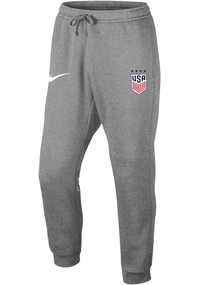 Get cozy in these Team USA Grey Club Sweatpants! Whether you're relaxing watching the game or just out running errands, these Team USA Shop Sweats are the perfect way to show your Team USA spirit in comfort and style. These Team USA Sweatpants also feature a fleece material with an elastic drawstring waistband, ankle cuffs and team graphics on the left hip. Classic jogger silhouette, Brushed-back fleece, Tapered leg and rib cuff for comfortable fit, Side seam pockets, Back snap pocket, Fold over Gray Sports Pants With Ribbed Cuffs, Cotton Athleisure Pants For Sports Events, Nike Fleece Activewear For Sports Events, Sportswear Bottoms With Pockets For Sports Events, Team Spirit Cotton Bottoms For Sports Events, Moisture-wicking Cotton Pants For Sports Season, Moisture-wicking Cotton Pants For Sports, Nike Sports Bottoms With Ribbed Cuffs, Cotton Sports Bottoms With Team Spirit Style