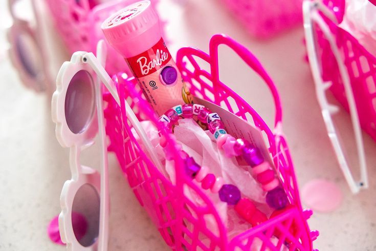 a pink shopping cart filled with lots of toys